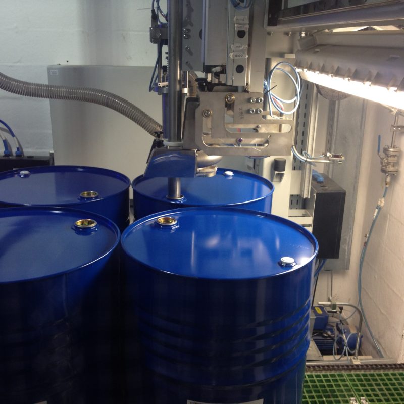 SP3 filling head lowering over blue drums on a pallet