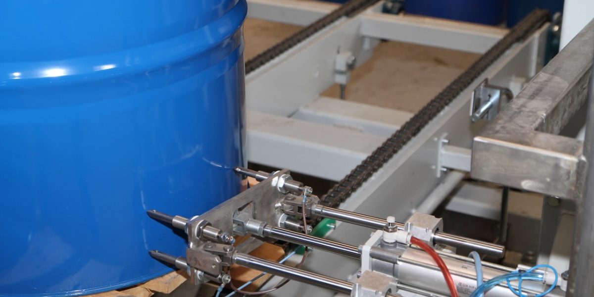 SP3 pneumatic mechanism beside a blue drum on the conveyor
